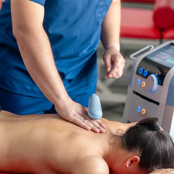 Doctor using machine to treat the back of a patient. Doctor using machine to treat the back of a patient, T-CaRe technology, Resistive and Capacitive therapy.